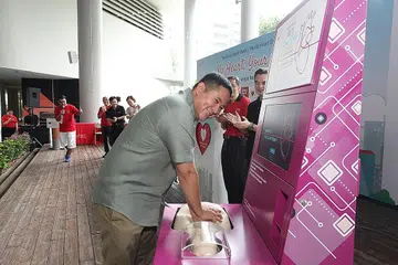 KEMAHIRAN PENTING: Encik Amrin mencuba kiosk pembelajaran sendiri CPR versi dua di acara Minggu Jantung Nasional dan Hari Jantung Sedunia 2019 kelmarin. - Foto SINGAPORE HEART FOUNDATION