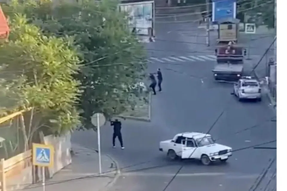 Kelihatan lelaki bersenjata sedang melakukan tembakan dari arah sebatang jalan raya di Makhachkala, Russia.