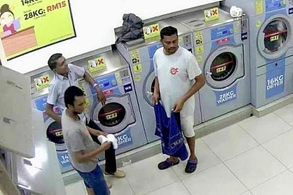 Video tular itu menunjukkan seorang lelaki membuka pintu pengering manakala seorang lagi lelaki menolak seekor kucing ke dalam, sebelum mereka menghidupkan mesin itu dan tinggalkan tempat itu. - Foto GAMBAR TANGKAP LAYAR/YOUTUBE