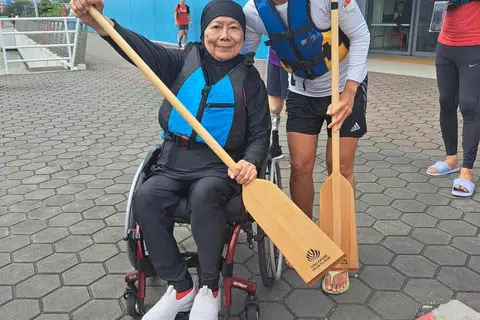 Cik Asiah Ibrahim sedang bersiap sedia untuk kegiatan mendayung bot naga pada hujung minggu.