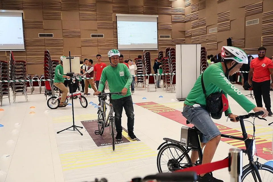 PROGRAM LATIHAN BARU: Dalam satu pameran semalam, pekerja penghantaran Grab berpeluang mendapatkan maklumat tentang program latihan baru, antaranya mengenai keselamatan jalan raya. Penunggang Grab yang tamat menjalani program itu akan menerima satu 'topi keledar bijak' secara percuma, yang membolehkan mereka memberi isyarat lampu untuk menunggang dengan lebih selamat. - Foto BH oleh ONG WEE JIN