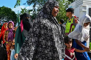 DIUSIR: Pelarian Rohingya keluar dari perkarangan bangunan pemerintah selepas pelajar universiti menyerbu tempat perlindungan sementara mereka dan memaksa mereka supaya berpindah ke tempat lain, dalam kejadian di Banda Aceh pada 27 Disember.