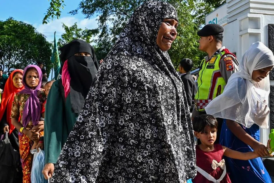 DIUSIR: Pelarian Rohingya keluar dari perkarangan bangunan pemerintah selepas pelajar universiti menyerbu tempat perlindungan sementara mereka dan memaksa mereka supaya berpindah ke tempat lain, dalam kejadian di Banda Aceh pada 27 Disember.