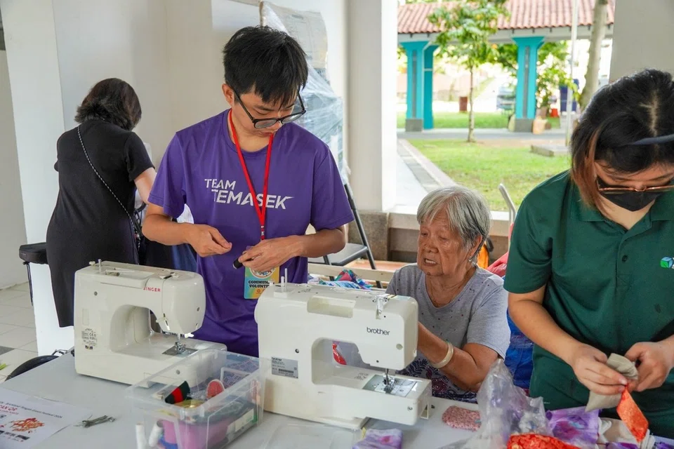 Penduduk warga emas (kedua dari kanan) turut serta stesen Garment Restoration untuk membantu membaik pulih pakaian dan menggunakan kain lebihan untuk dihasilkan kraf.
