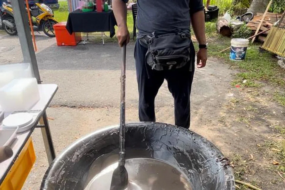 Encik Muhammad Amir Asyraf, 26 tahun, mengacau dodol atau juga dikenali sebagai penganan dalam kalangan masyarakat Negeri Sembilan menggunakan kaedah tradisional dan resipi warisan neneknya.