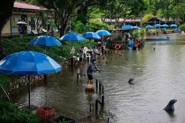 MEMANCING DALAM HUJAN: Mereka yang pergi ke D'Best Fishing di Pasir Ris Town Park hujung minggu lalu terpaksa memakai baju hujan bagi meredah hujan sambil memancing di situ. - Foto BH oleh KEVIN LIM