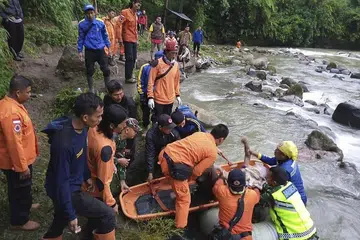 MISI MENCARI DAN MENYELAMAT: Penyelamat memindahkan mayat seorang mangsa dari bas yang telah terjunam ke sungai di dalam gaung sedalam 150 meter di kampung Perahu Dipo di daerah Pagaramalam, wilayah Sumatera Selatan, Indonesia, pada Isnin malam lalu. - Foto AP