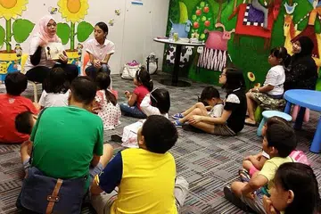 TANAM CINTA PADA BAHASA MELAYU: Cik Nur Fadhillah bersama temannya giat mengendali sesi bercerita di Perpustakaan Awam Bishan untuk menggalak penggunaan bahasa Melayu di kalangan kanak-kanak Melayu setempat. - Foto ihsan NUR FADHILLAH MUSA