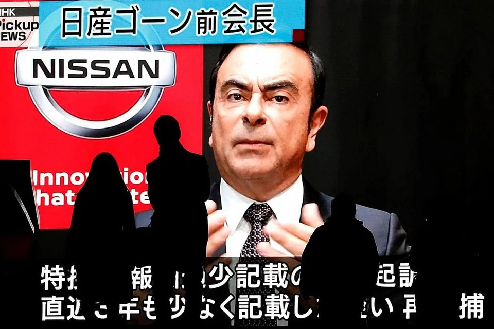 TANGKAPAN TERGEMPAR: Orang lalu lalang sedang sebuah monitor besar menayangkan berita siap dengan gambar Encik Carlos Ghosn dikenakan tuduhan dan ditangkap lagi di Tokyo pada 9 Disember lalu. - Foto REUTERS