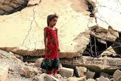 A Yemeni girl who was displaced with her family, stands amidst the rubble of a building that was destroyed in the civil war, in the district of Abs in Yemen's northwestern Hajjah province. - Photo AFP