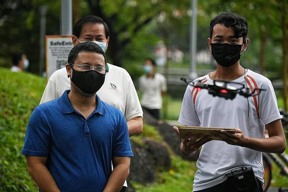 MEMANFAATKAN TEKNOLOGI DRON: Encik Desmond Lee menyaksikan demonstrasi pemeriksaan pokok secara maya menggunakan dron oleh pelajar ITE dan kakitangan NParks di Taman Bishan-Ang Mo Kio semalam. - Foto BH oleh KUA CHEE SIONG