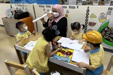 GURU CONTOH: Cik Nur'Aqilah Abdul Malek menerima Anugerah Pendidik Pembangunan Awal Kanak-Kanak Cemerlang di majlis Anugerah Ecda baru-baru ini bagi pengalamannya selama sedekad membangunkan kanak-kanak secara menyeluruh dan kerjasama proaktif bersama ibu bapa untuk mencapai hasil terbaik bagi anak mereka. - Foto NTUC FIRST CAMPUS