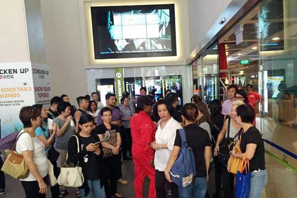 TIDAK DIBENARKAN MASUK: Orang ramai dan kakitangan mendapati pusat beli-belah Parkway Parade ditutup pagi semalam. - Foto THE STRAITS TIMES