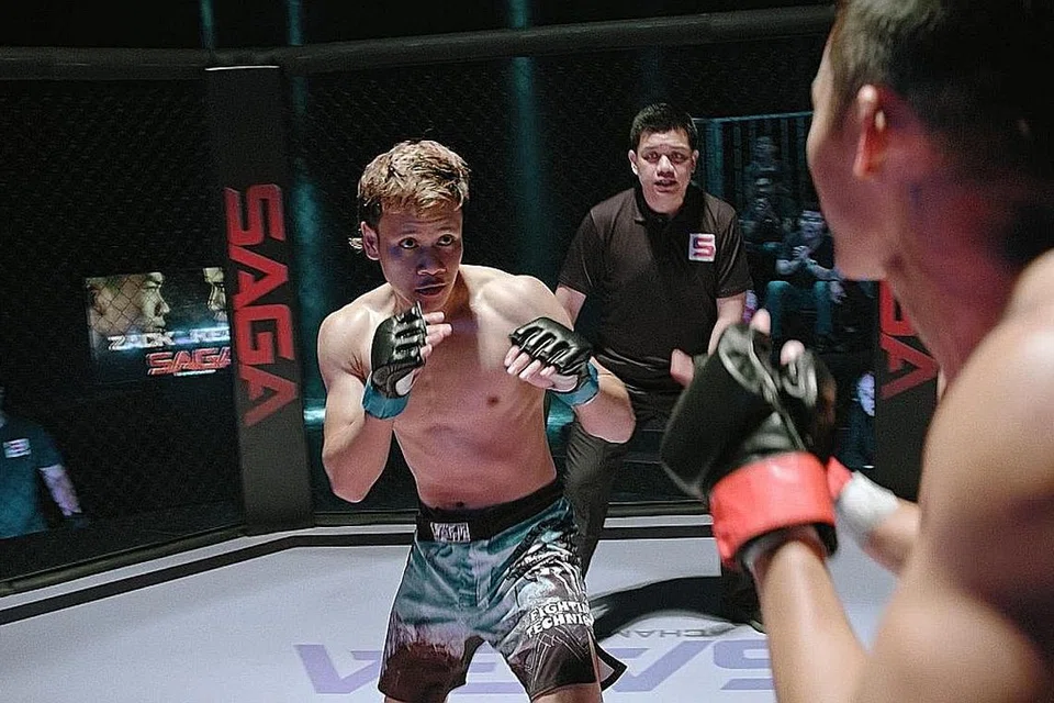 PENGALAMAN PERTAMA BERLAKON: Juara tinju profesional pertama Singapura, Muhamad Ridhwan Ahmad (kiri) bertarung dengan lawan dalam drama seni pertahan diri campuran (MMA), Saga 2.0 yang padat dengan pengajaran seperti kesetiaan, menghormati ibu bapa dan kisah kekeluargaan dan sesuai buat tontonan seisi keluarga. - Foto MEDIACORP SURIA