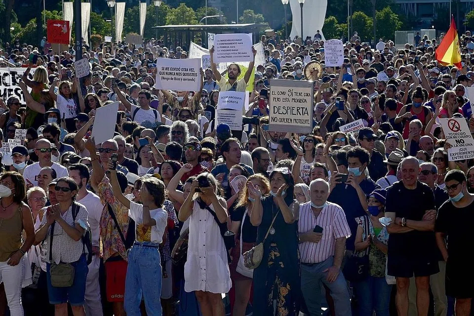 TUNJUK PERASAAN, MAHU KEBEBASAN: Orang ramai berkumpul dengan membawa poster sambil meneriak slogan bagi melahirkan bantahan terhadap sekatan bagi menentang Covid-19 seperti penggunaan pelitup secara wajib di Madrid, Ahad lalu. - Foto AFP