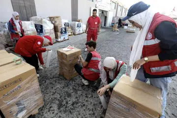 SEDIA BANTUAN: Pekerja dan sukarelawan Persatuan Bulan Sabit Merah Mesir mengendalikan bantuan kemanusiaan untuk rakyat Palestin di Semenanjung Gaza, di sebuah gudang di Arish, Mesir, pada 25 Oktober 2023.