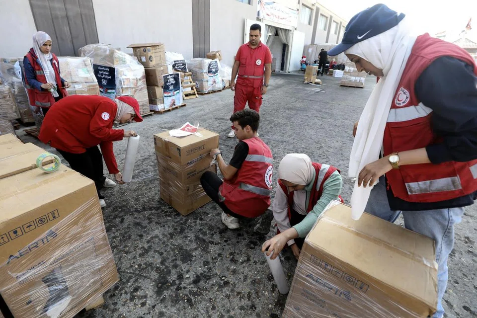 SEDIA BANTUAN: Pekerja dan sukarelawan Persatuan Bulan Sabit Merah Mesir mengendalikan bantuan kemanusiaan untuk rakyat Palestin di Semenanjung Gaza, di sebuah gudang di Arish, Mesir, pada 25 Oktober 2023.