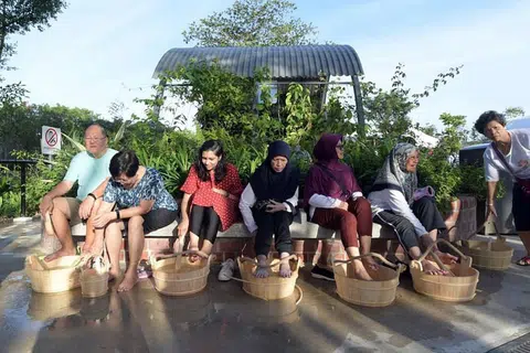 DIBUKA SEMULA: Pengunjung merendam kaki mereka di Taman Mata Air Panas Sembawang yang dibuka semula pada 4 Januari 2020. 