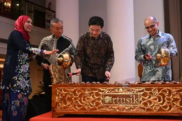 Perdana Menteri Encik Lawrence Wong (dua dari kanan) diperkenalkan alat muzik, Saronang Penerus, di majlis Ulang Tahun ke-60 Lembaga Biasiswa Kenangan Maulud (LBKM). Beliau ditemani (dari kiri) pengasas bersama Artusik, Cik Nabillah Jalal; mantan Presiden LBKM, Encik Suhaimi Salleh; Presiden terkini LBKM, Encik Dr Syed Harun Alhabsyi. 