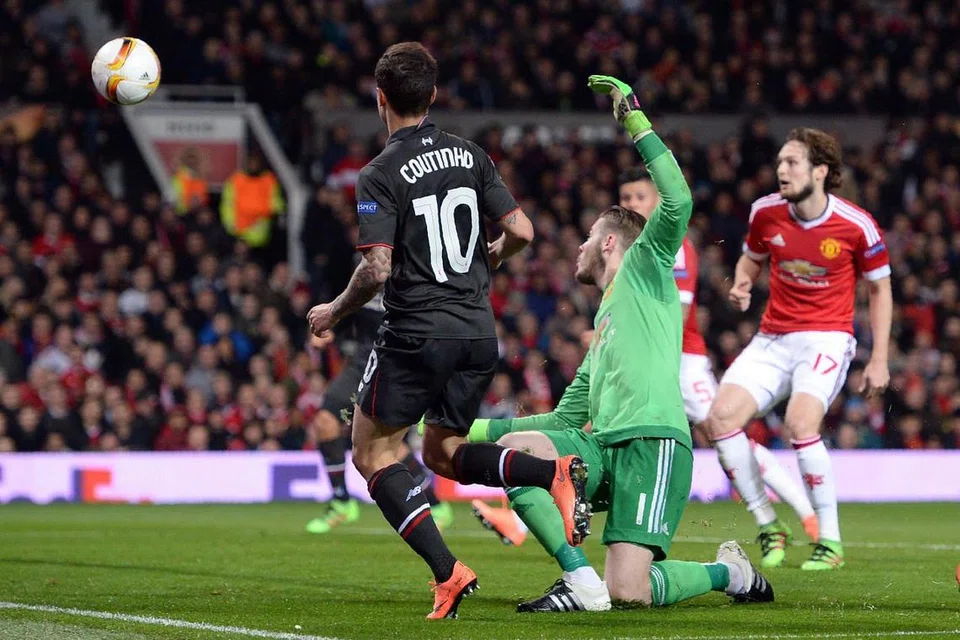 Philippe Coutinho menewaskan penjaga gol Manchester United, David de Gea (jersi hijau), untuk menjaringkan gol penyamaan 1-1 bagi Liverpool, dalam perlawanan kedua mereka di peringkat 16 pasukan Liga Europa di Old Trafford pada Khamis (18 Mac) 