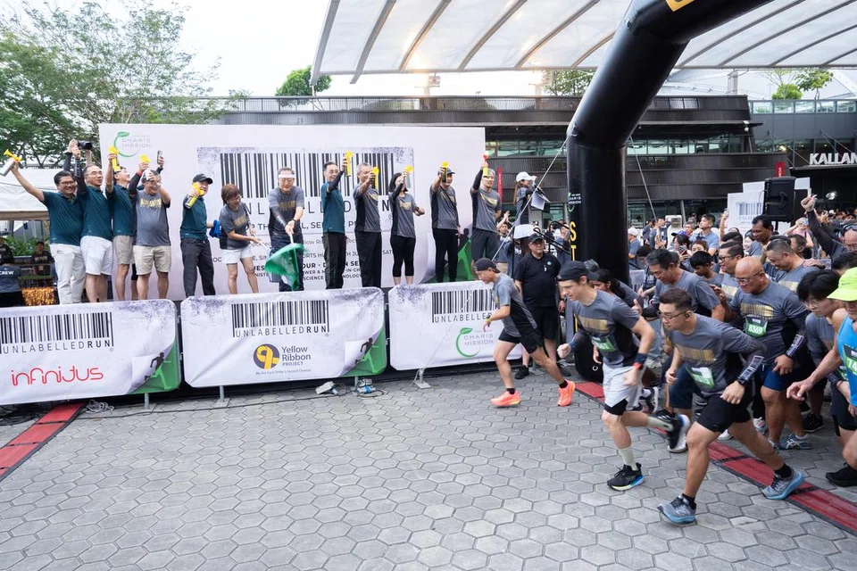 Menteri Tenaga Manusia, Dr Tan See Leng, (tujuh dari kiri) dan Mayor Majlis Pembangunan Masyarakat (CDC) Central, Cik Denise Phua (enam dari kiri) memulakan perlumbaan larian The Unlabelled Run 2025 di OCBC Square pada 28 Jun.