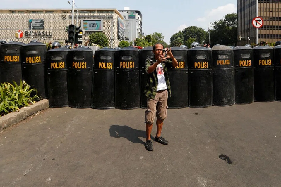 SIAP PERTAHAN KEAMANAN: Barisan pegawai polis bersiap mengawal keadaan menyusuli keputusan pilihan raya presiden Indonesia berdekatan ibu pejabat Badan Pengawas Pemilihan Umum Indonesia (Bawaslu) kelmarin. - Foto REUTERS 
