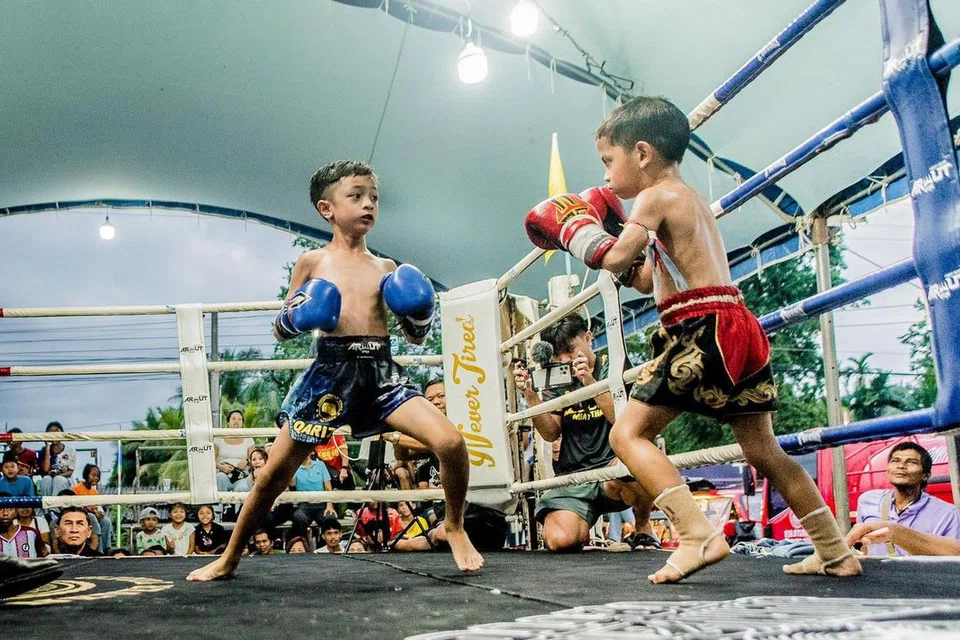 Atlet Muay Thai Singapura berusia tujuh tahun, Qarizh Fadel Mohammad Fadeli (kiri), berlawan dengan seteru dari Thailand dalam pertandingan profesional Muay Thai di bandar Nakhon Si Thammarat, selatan Thailand, pada 30 November.