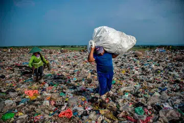 USAHA KURANGKAN SISA: Pengaut mengambil sisa di tempat buang sampah di Sidoarjo, Jawa Timur. Ulama kini mengadakan 'ngaji sampah' di seluruh Indonesia bagi meningkatkan kesedaran tentang pentingnya mengurangkan sisa plastik dan menjelaskan cara sisa plastik memburukkan bencana alam. - Foto AFP