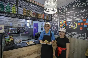 TIDAK LAGI RASA MALU: Encik Muhammad Muhaimin Mohd Afandi mampu menyesuaikan diri di dapur Kafe Mystical dan dengan mereka yang melanggani kafe yang diuruskan Pusat bagi Golongan Dewasa (CFA), Persatuan Golongan Keperluan Khas (APSN), berkat bimbingan Cik Nur Suriani Lamri. - Foto BM oleh IQBAL FAIZAL