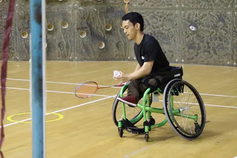 PERKASA DIRI DENGAN BADMINTON: Encik Akram Ramadan Misrawi, yang mengalami displasia rangka atau pertumbuhan tulang dan rawan tangan serta kaki yang terjejas, teruja dapat mewakili negara dalam sukan badminton berkerusi roda. - Foto POLITEKNIK NANYANG