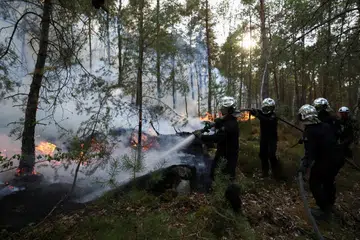 Anggota bomba menyembur air bagi memadamkan kebakaran hutan di Hutan Fontainebleau, Noisy-sur-Ecole, berhampiran Paris, pada 13 Julai 2026. Kebakaran yang tercetus ketika Perancis dilanda gelombang haba ketiga tahun ini memusnahkan lebih 1,300 hektar hutan, memaksa kira-kira 1,000 penduduk dipindahkan dan mencetuskan siasatan pihak berkuasa selepas mengesyaki kebakaran itu mungkin berpunca daripada perbuatan khianat.