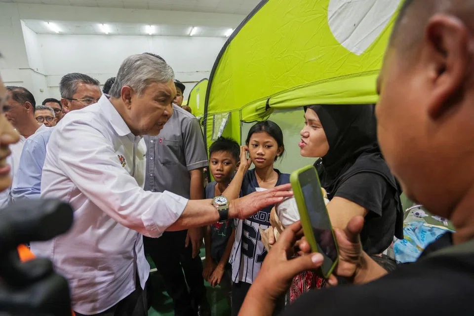 Timbalan Perdana Menteri Malaysia, Datuk Seri Dr Ahmad Zahid Hamidi (kiri), menziarahi mangsa banjir di Sabah yang ditempatkan di pusat pemindahan sementara (PPS) di Taman Sri Keramat, Putatan, pada 17 September. 