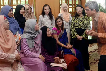 BERI MAKLUM BALAS: Dr Yaacob (kanan) berinteraksi dengan beberapa daripada 150 pegawai perkhidmatan awam yang menghadiri jamuan tengah hari sempena Hari Raya Aidilfitri di Hotel Regent Singapore semalam. - Foto TAUFIK A. KADER