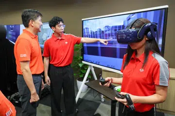 Setiausaha Agung NTUC, Encik Ng Chee Meng (kiri), menyaksikan demonstrasi sistem latihan, Realiti Maya (VR) SMRT sewaktu lawatan ke Depoh Bishan pada 31 Oktober. Sistem tersebut membolehkan pekerja berlatih membaiki kerosakan dan menjalankan tugas penyelenggaraan.