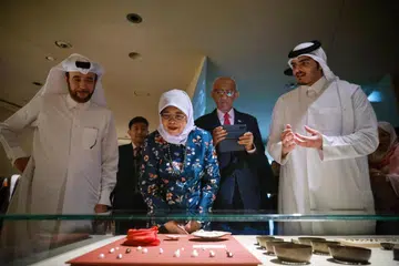 KUNJUNGAN KE MUZIUM: Presiden Halimah Yacob melihat permata yang dipamerkan di Muzium Negara Qatar. Bersamanya ialah suami, Encik Mohamed Abdullah Alhabshee (dua dari kanan); Duta Qatar ke Singapura, Encik Saoud Jassim Mohammed Al Jufairi (kiri) dan pengarah muzium, Sheikh Abdulaziz bin Hamad Al Thani (kanan).