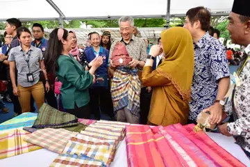 Encik Lee Hsien Loong cuba mengenakan tanjak dan samping semasa karnival Hari Raya anjuran GRC Ang Mo Kio dan SMC Sengkang West pada 2019.