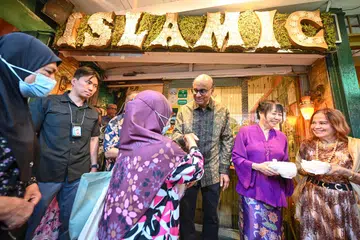 Presiden Tharman Shanmugaratnam (tiga dari kanan) dan isterinya Puan Jane Ittogi (dua dari kanan) hadir sebagai tetamu kehormat bagi mengagihkan set beriani di Restoran Islamic pada 7 April sempena meraikan ulang tahun ke-103 restoran tersebut. 