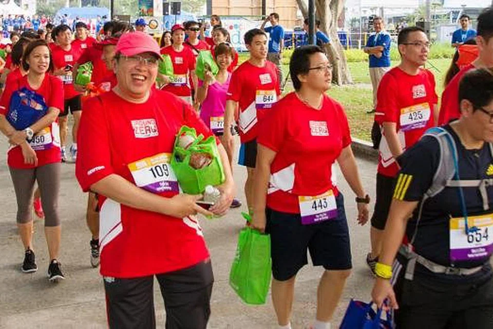 CABARAN UNIK: Peserta perlu mengangkat 'pek bantuan' seberat 5.1 kilogram sepanjang perlumbaan lima kilometer itu. - Foto-foto MERCY RELIEF
