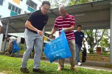 JAGA KEBERSIHAN: Dr Teo Ho Pin (kiri) dan Encik Masagos bergotong-royong dengan penduduk membersihkan sekitaran kawasan Petir Road dalam satu kegiatan di bawah inisiatif 'Keep Clean, Singapore!' yang dilancarkan semalam. - Foto KHALID BABA