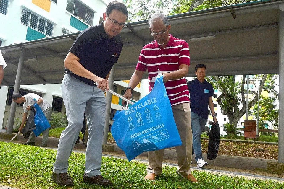 JAGA KEBERSIHAN: Dr Teo Ho Pin (kiri) dan Encik Masagos bergotong-royong dengan penduduk membersihkan sekitaran kawasan Petir Road dalam satu kegiatan di bawah inisiatif 'Keep Clean, Singapore!' yang dilancarkan semalam. - Foto KHALID BABA