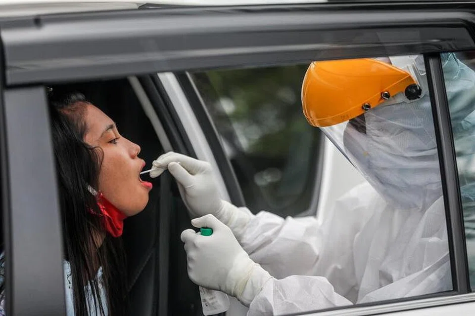 TANGANI COVID-19: Di Indonesia, seorang pekerja jagaan kesihatan melakukan ujian Covid-19 ke atas seorang penumpang kereta di Medan. - Foto EPA-EFE 