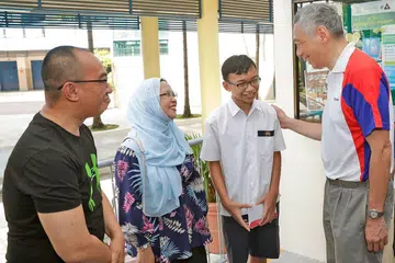 CONTOH CEMERLANG: Encik Lee (kanan) beramah mesra dengan Muhammad Anarkin Fitri bersama bapanya, Encik Aidil Abbas dan ibunya, Cik Murnilima Osman. - Foto BH oleh KEVIN LIM