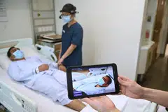 Seorang pekerja di hospital menunjukkan bagaimana kecerdasan buatan dimanfaatkan untuk mengubah cara pekerja penjagaan kesihatan menjaga pesakit.