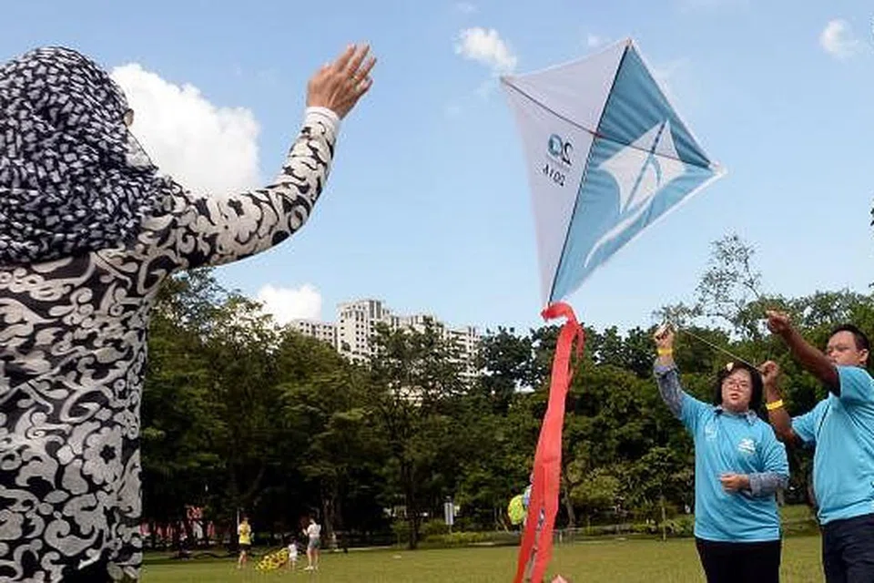 KARNIVAL DSA: Cik Ratna (kiri) bersama anaknya, Cik Nadhrah Daud, dan temannya, Encik Ahmad Salim, bermain layang-layang di karnival DSA semalam. - Foto JOHARI RAHMAT