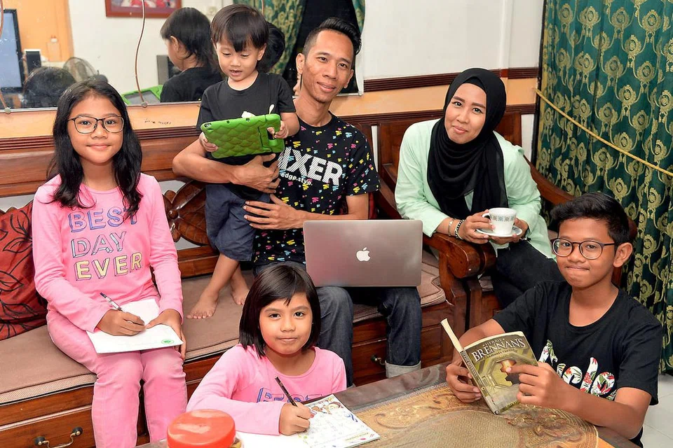 ALU-ALUKAN SOKONGAN PEMERINTAH: Encik Muhammad Hadi Hanafi (dengan komputer riba) bersama isterinya Haslinda Mohd Salleh menyambut baik bantuan pemerintah melalui Belanjawan ini yang turut bermanfaat bagi keluarganya yang merangkumi empat anaknya, (dari kiri) Adlina Mizsyaieza, Adlini Miqaiela (duduk), Adli Miqaiel dan Adlin Mirza. - Foto M.O. SALLEH