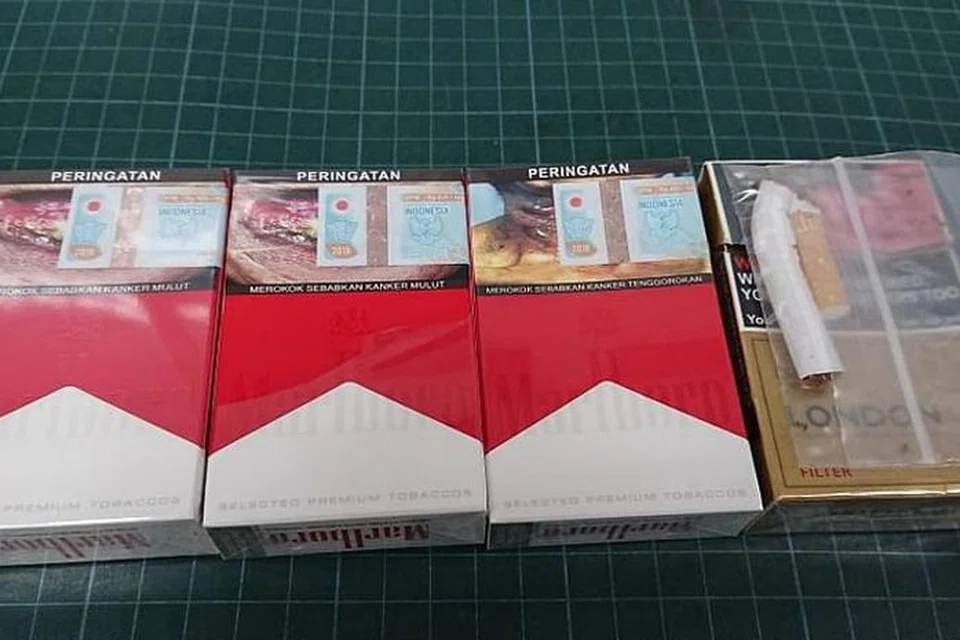 DIKENAKAN DENDA: Hasil pemeriksaan lanjut di tempat kerja dan rumahnya, sebanyak tiga peket dan 10 batang rokok terlarang milik lelaki itu telah ditemui. - Foto FACEBOOK/ KASTAM SINGAPURA