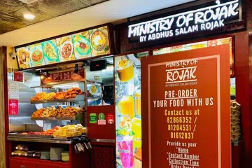 MANFAATKAN SKIM: Ministry of Rojak terjejas akibat Covid-19 tetapi dapat pulih sedikit selepas pasangan Cik Nadira Ahamed Basir dan suaminya, Encik Abdus Salam s/o Akber Ali mendapatkan bantuan Pusat SME bagi mendapatkan Pakej F&B Booster yang mengurangkan kos perniagaan dan membolehkan kedai makanan itu menyediakan khidmat penghantaran serata Singapura. Gambar ini diambil sebelum wabak Covid-19 melanda negara. - Foto MINISTRY OF ROJAK