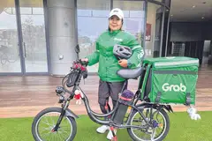 HARAP PERLINDUNGAN DAPAT DISEDIAKAN: Pekerja penghantaran GrabFood, Cik Nuraini Mohd Yusof, berharap bantuan dan perlindungan dapat disediakan kepada golongan pekerja seperti beliau yang bekerja tanpa kontrak pekerjaan dan perlu mengharungi pelbagai cabaran di luar kawalan mereka. - Foto ihsan NURAINI MOHD YUSOF