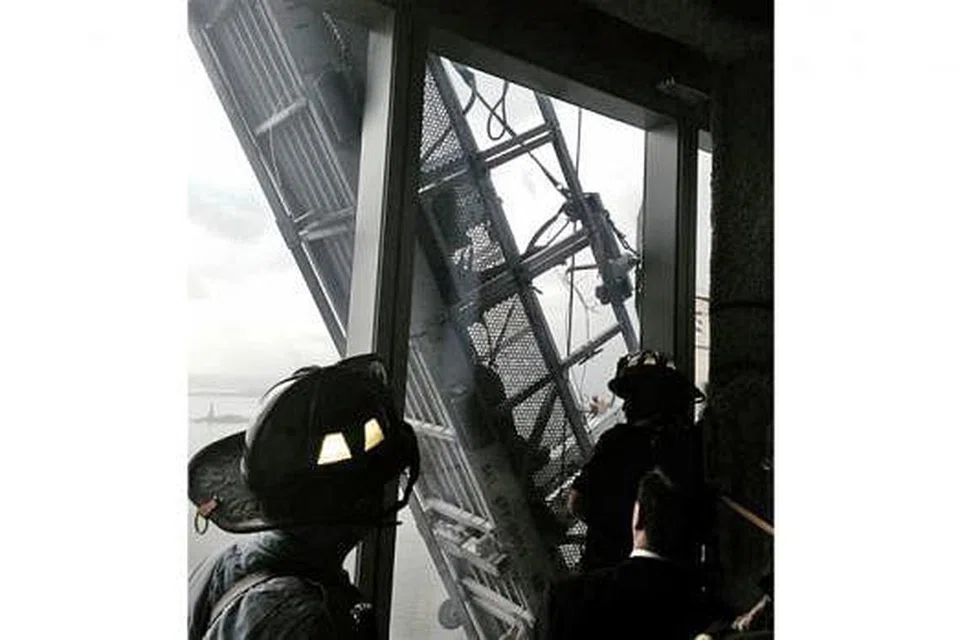 CUBA SELAMATKAN: Ahli bomba cuba menyelamatkan pekerja pencuci tingkap di luar World Trade Centre di New York, kelmarin. - Foto REUTERS 