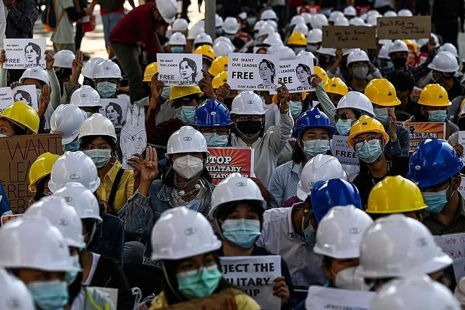 TOLAK JUNTA: Rakyat Myanmar berkumpul dan menjulang sepanduk dan tulisan mendesak pembebasan Kaunselor Negara, Cik Aung San Suu Kyi, semasa bantahan di ibu kota komersial Yangon, semalam. - Foto AFP